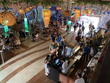 Zona de comedor tipo food court con varias estaciones de comida